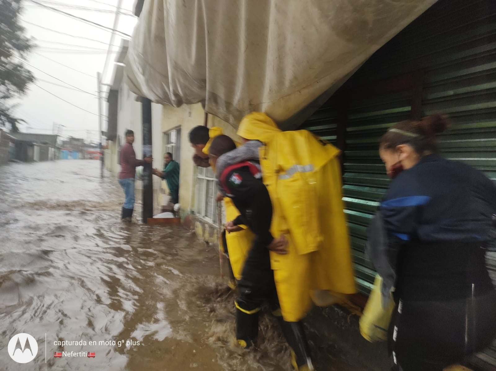 Bombero carga a una persona para ayudarla a llegar a su casa