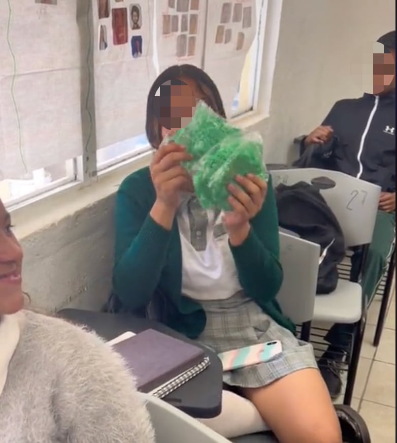 Alumna extranjera lleva papel picado por Día de Muertos